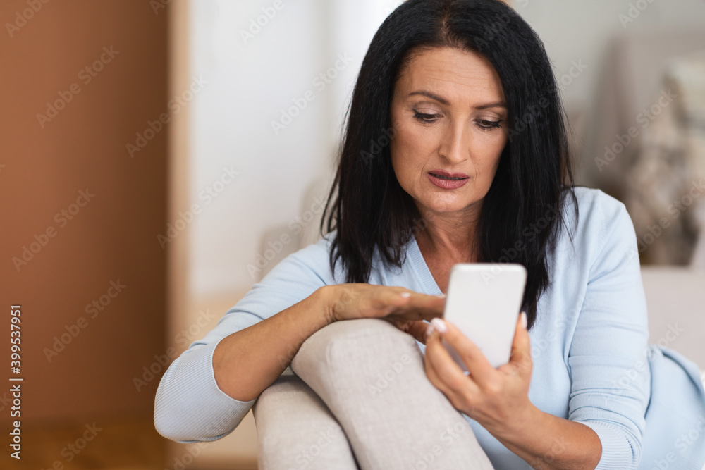 Portrait of mature woman using smartphone at home Portrait of mature woman using smartphone at home