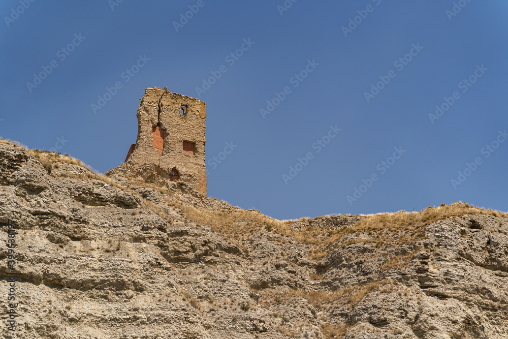 View of outer wall of stone old tower of fortress in spanish desert