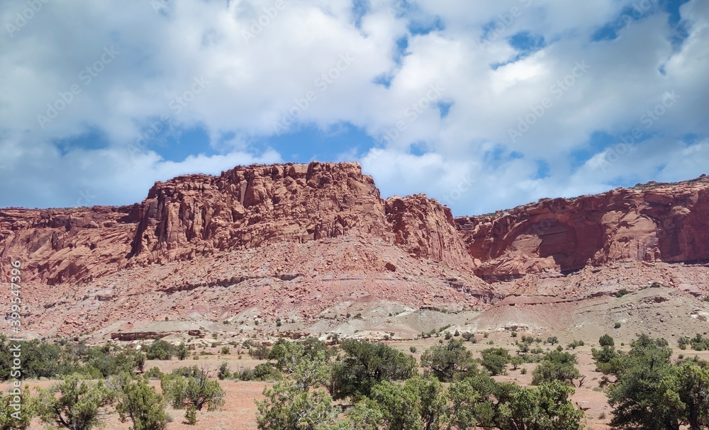 Amazing sandstone monoliths in a barren desert prairie on a blue partly cloudy summer day at Capitol Reef National Park in Torrey Utah