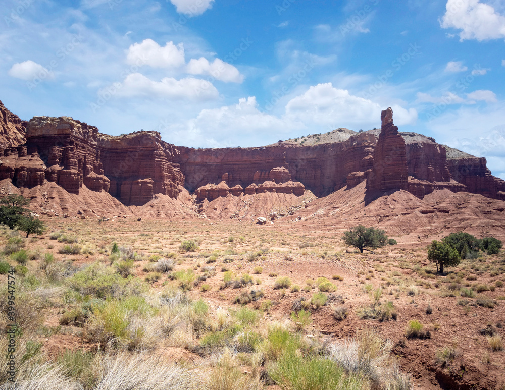 Amazing sandstone monoliths in a barren desert prairie on a blue partly cloudy summer day at Capitol Reef National Park in Torrey Utah Amazing sandstone monoliths in a barren desert prairie on a blue partly cloudy summer day at Capitol Reef National Park in Torrey Utah