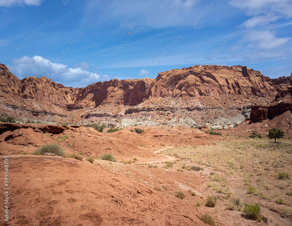 Amazing sandstone monoliths in a barren desert prairie on a blue partly cloudy summer day at Capitol Reef National Park in Torrey Utah