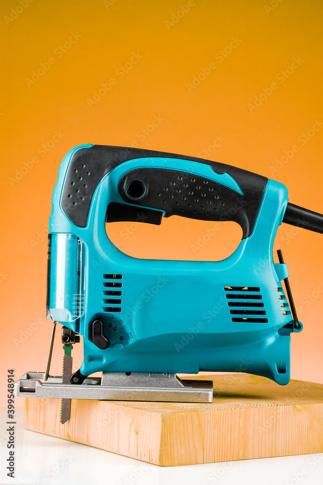 Professional electric Jigsaw saw with round handle isolated on yellow background Professional electric Jigsaw saw with round handle isolated on yellow background