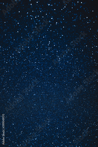 Abstract blue blurred sparkling background with focused area. Holiday festive concept. Glitter confetti. Christmas lights. 