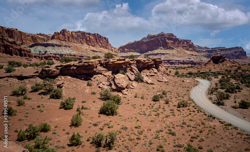 Amazing sandstone monoliths in a barren desert prairie on a blue partly cloudy summer day at Capitol Reef National Park in Torrey Utah photo