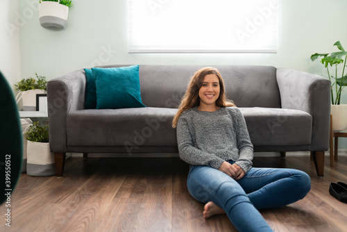 Good-looking young woman chilling on the floor of her apartment