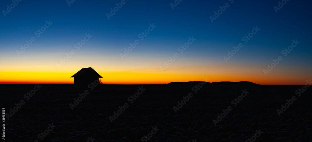 Old barn on the field at sunrise