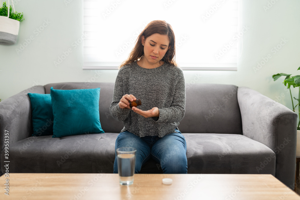 Obraz premium Good-looking woman taking the pills prescribed by her doctor
