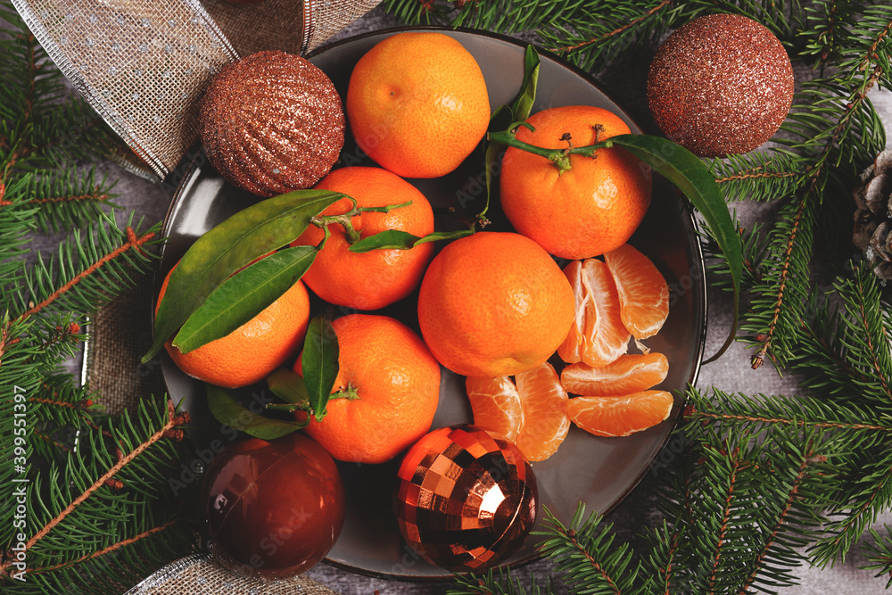 christmas composition on plate with oranges and fir tree, on gray background christmas composition on plate with oranges and fir tree, on gray background