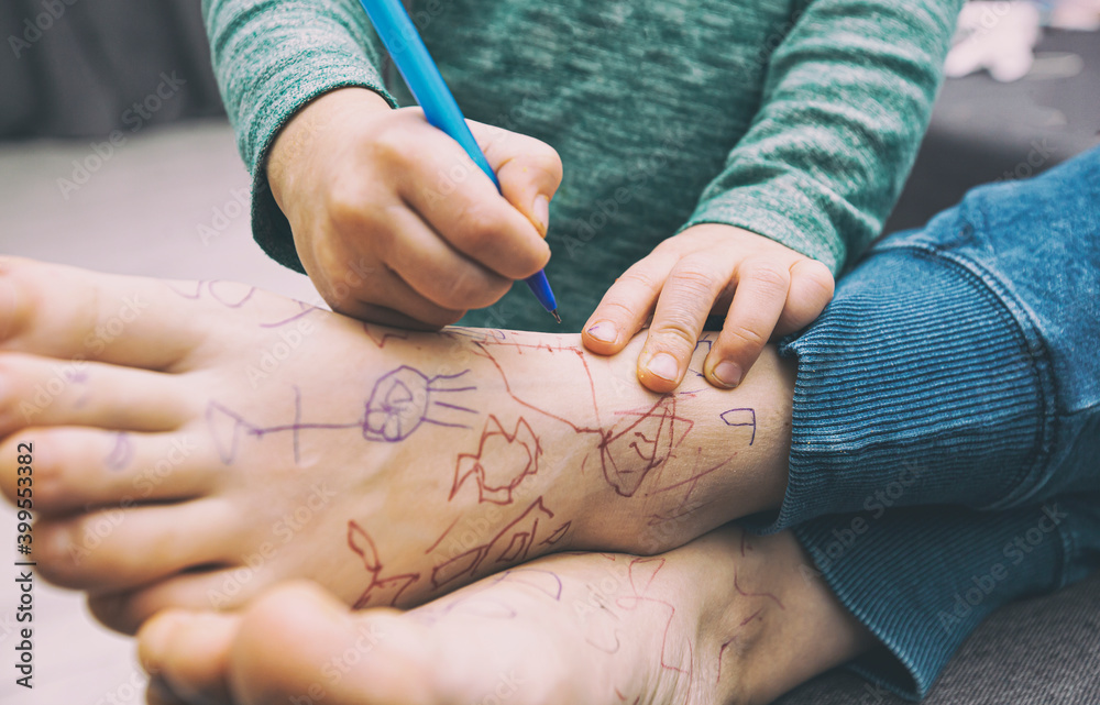 Obraz premium the child made a surprise to mom painted her legs with a pen while she slept