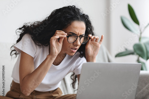 Canvas-taulu Young woman with bad eyesight using laptop, wearing glasses