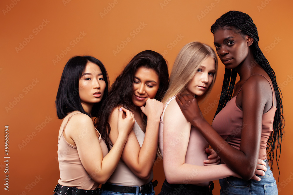 Obraz premium young pretty asian, caucasian, afro woman posing cheerful together on brown background, lifestyle diverse nationality people concept