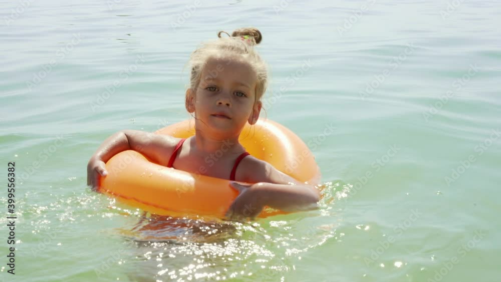 Child swims sea inflatable ring. danger of drowning Safety equipment, Child Life buoy Little Caucasian girl have fun in sea water Summer vacation active leisure. Lifestyle Child swims sea inflatable ring. danger of drowning Safety equipment, Child Life buoy Little Caucasian girl have fun in sea water Summer vacation active leisure. Lifestyle