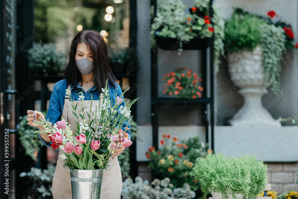 Woman florist at her own floral shop taking care of flowers Woman florist at her own floral shop taking care of flowers