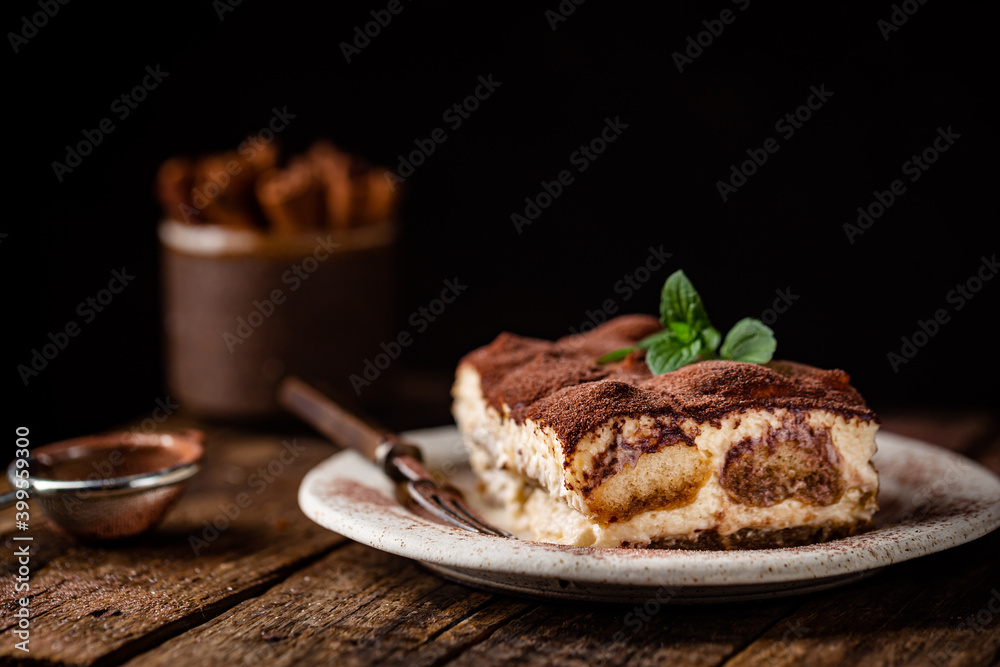 Piece of traditional Italian dessert tiramisu on dark background Piece of traditional Italian dessert tiramisu on dark background