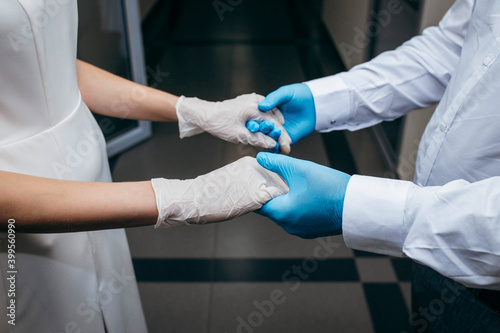 Groom and bride in rubber gloves hold hands