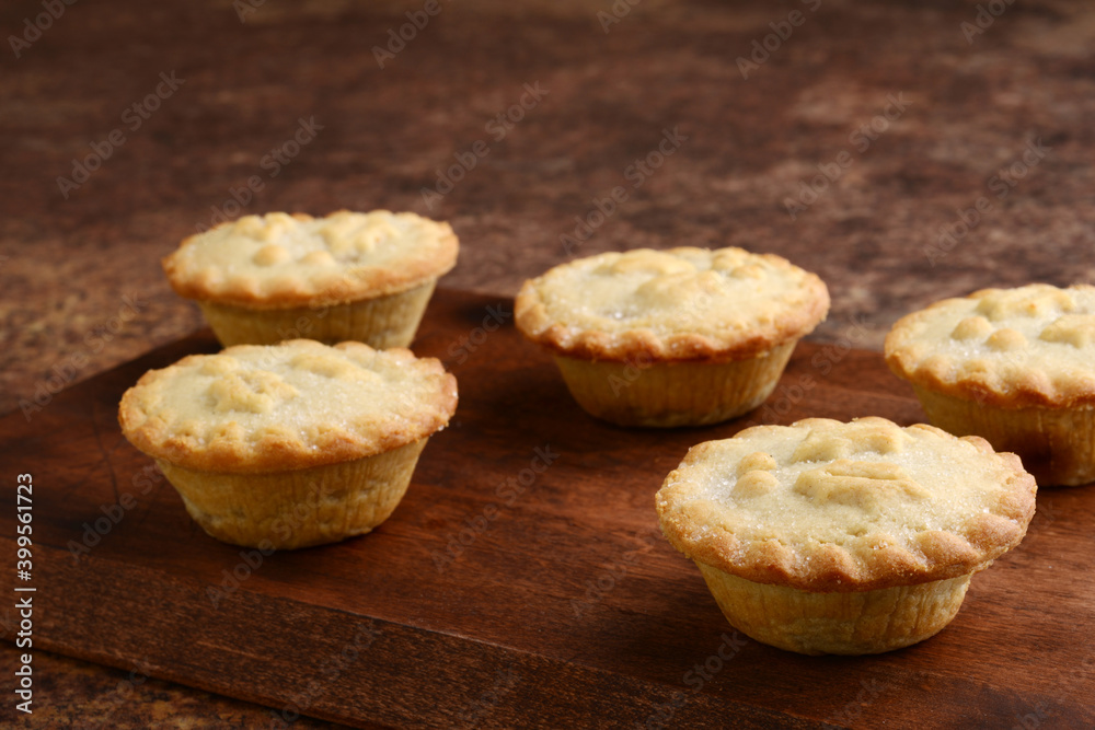 mincemeat pies on cutting board focus on front right pie