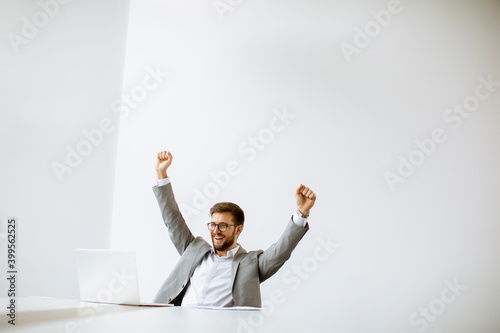 Young man working on laptop in bright office