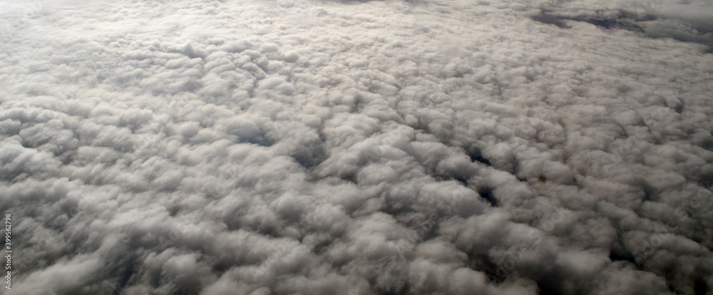 Fototapeta premium Aerial view of clouds and sky. Bird eye view from airplane window. Clouds panorama from airplane
