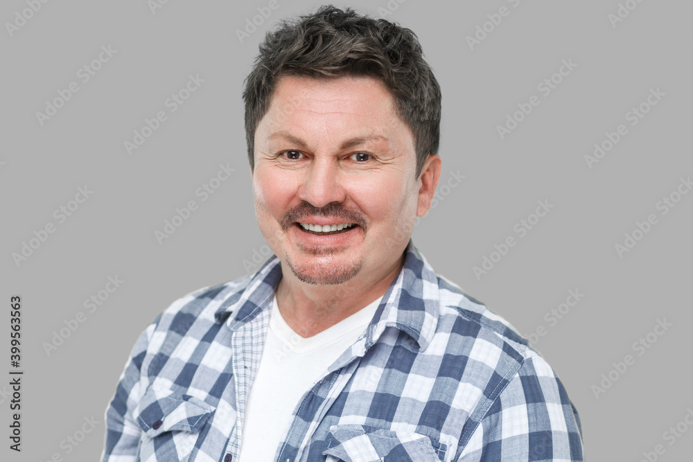 Portrait of happy successful handsome middle aged business man in casual checkered shirt, mustache standing and looking at camera with toothy smile. indoor studio shot, isolated on gray background. Portrait of happy successful handsome middle aged business man in casual checkered shirt, mustache standing and looking at camera with toothy smile. indoor studio shot, isolated on gray background.