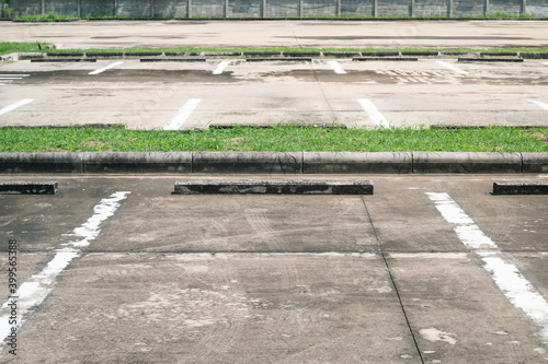 Empty parking lots in outdoor area against grass growing on parking lot islands.