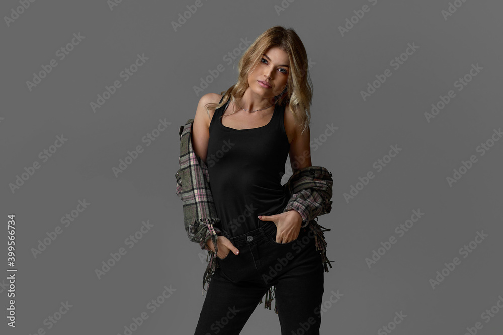 portrait of beautiful blonde woman with curly hair in jacket on chair on studio background. copy space portrait of beautiful blonde woman with curly hair in jacket on chair on studio background. copy space