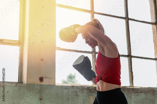 Indoors portrait of young, fit female boxer. Sport, active lifestyle. © stivog