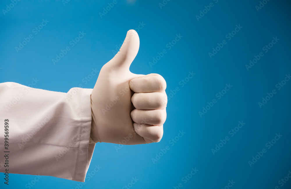 hand of doctor doing ok symbol, with surgical glove and blue background hand of doctor doing ok symbol, with surgical glove and blue background
