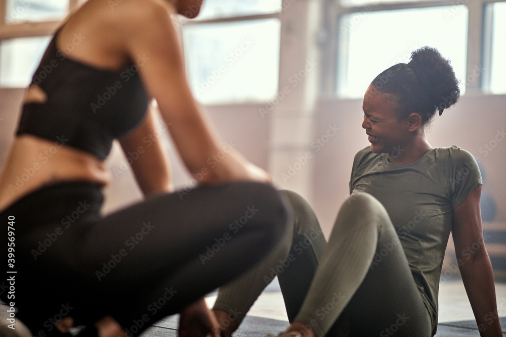 Woman laughing after workout with a partner in a gym