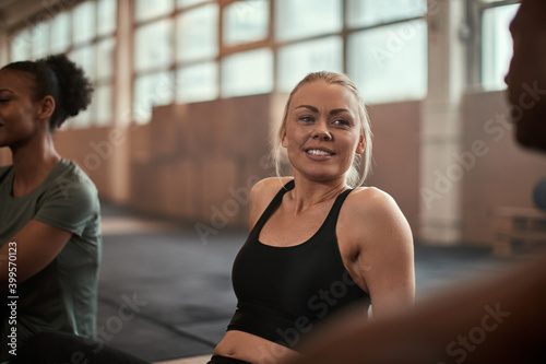 Smiling young woman talking with friends after a workout © Flamingo Images