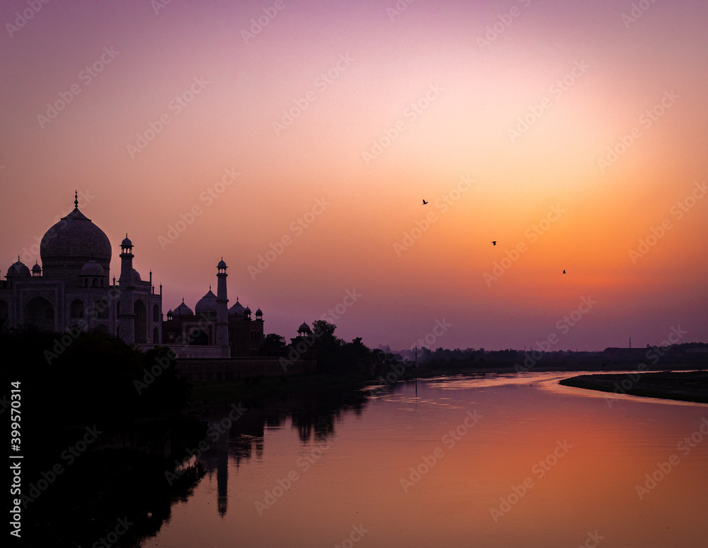 sunset over the river beside taj mahal 