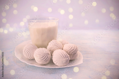 Winter still life with marshmallows,  milk, candle  on the wooden background. Copy space.