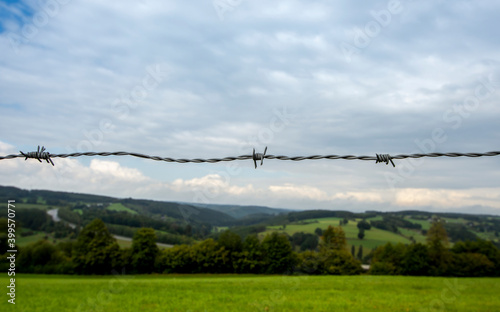 Obraz na płótnie Barbed wire - boundary concept - in a hill landscape
