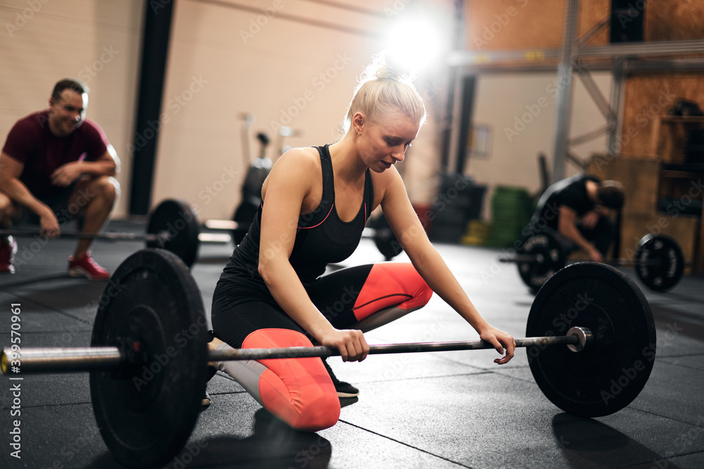 Fit young woman looking tired after a weightlifting class