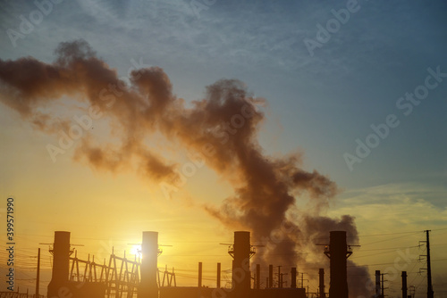 At dusk  the thermal power plants with factory pipe polluting air during sunrise