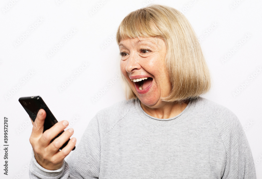 Portrait of old smiling lady looking at screen of mobile phone. Portrait of old smiling lady looking at screen of mobile phone.
