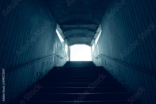 Stairs to the dark underpass, entrance to the dark underpass, view from inside in cold colors.