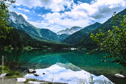 
Lake Anterselva, suggestive Alpine scenery in Trentino Alto Adige, crystal clear water with a perfect reflection, wooden walkway and suggestive viewpoints photo