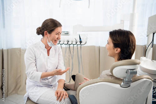Young female doctor talking to her patient in her dental office.