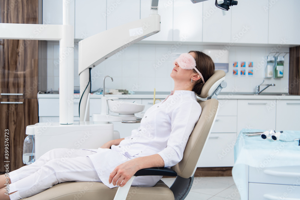 A dentist relaxing in her office after a long work day. A dentist relaxing in her office after a long work day.
