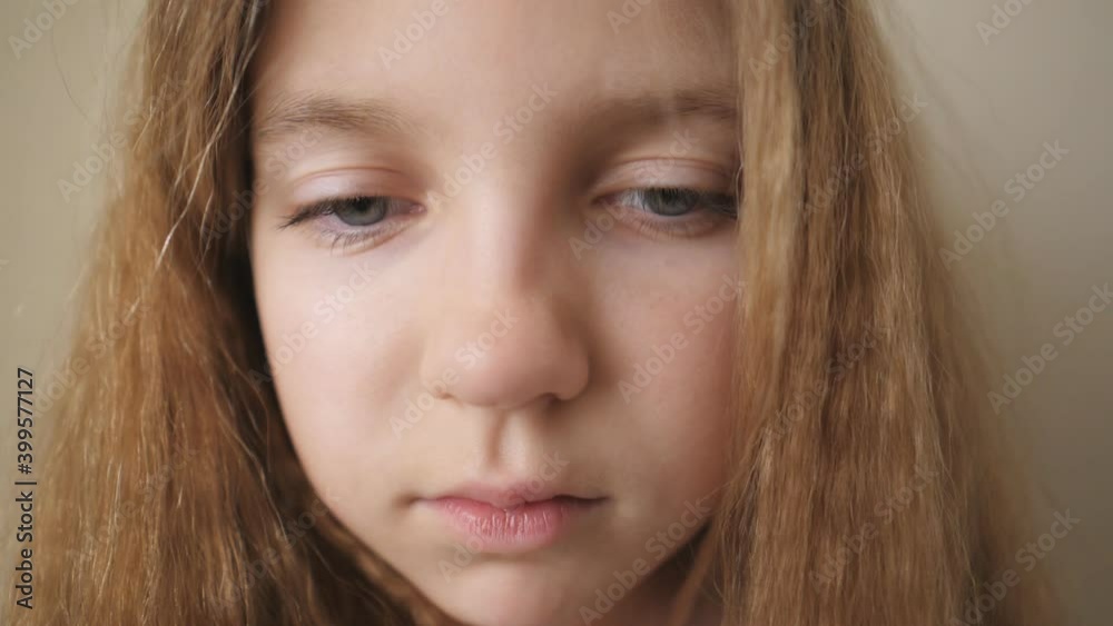 Close up female face of desperate child looking down indoor. Portrait of little blonde girl with sorrowful expression inside. Disappointed gaze of small upset kid Close up female face of desperate child looking down indoor. Portrait of little blonde girl with sorrowful expression inside. Disappointed gaze of small upset kid