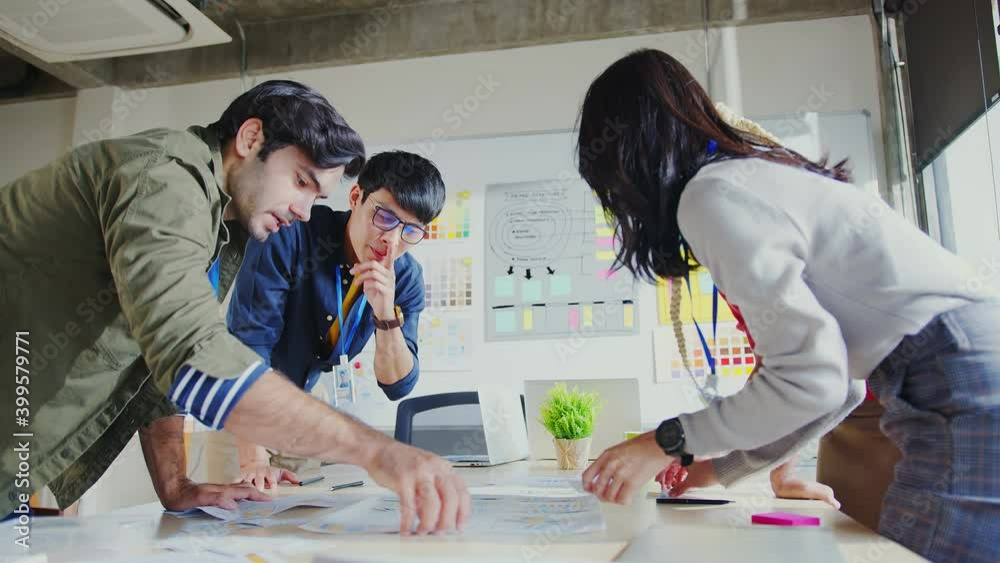 Meeting of UX developer and UI designer brainstorming about mobile app interface workflow design on table with coworker breif and color code at co-working space.Creative digital development agency.