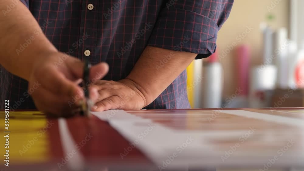 Man cutting print paper with scissors Man cutting print paper with scissors