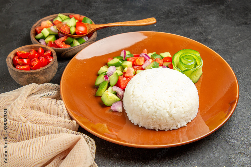 Side view of vegan dinner with rice and different types of vegetables on dark background