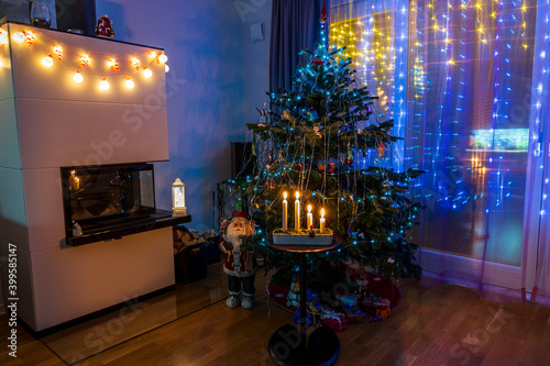 View of room with Сhristmas decoration and view of traditional advent candlestick with four lighted candle symbolizing fourth advent Beautiful Сhristmas backgrounds.