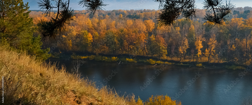 Beautiful panorama of the autumn forest, across the river on the mountain hills.