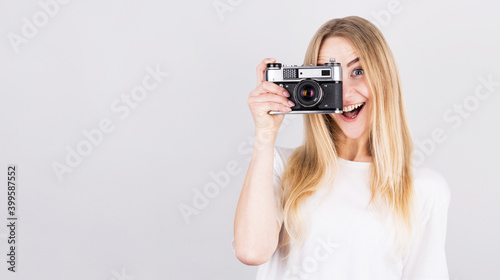 Happy smiling young girl holding camera and taking photos © MP Studio