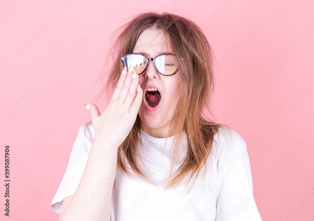 Tired woman yawning covering open mouth with hand need rest. Young female worker being sleepy head can't wake up having insomnia. Tired woman yawning covering open mouth with hand need rest. Young female worker being sleepy head can't wake up having insomnia.