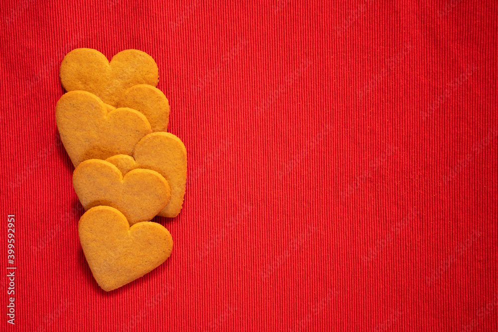 Obraz premium Happy valentine's day, heart shaped gingerbread cookie on red background with copy space