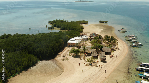 Beautiful beach on tropical island surrounded by coral reef, sandy bar with tourists. honda bay top view. Starfish island. Summer and travel vacation concept, Philippines, Palawan