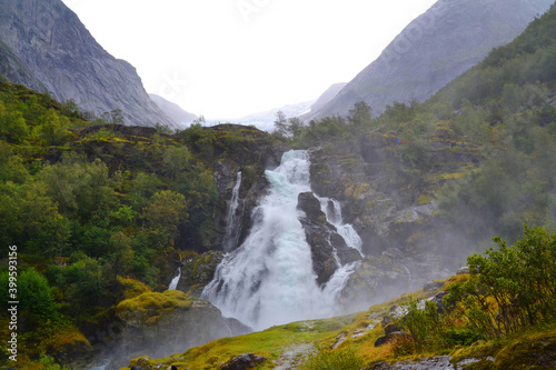 Beautiful waterfall in the Jostedalsbreen National Park in Norway. Pathway to Briksdal or Briksdalsbreen glacier in Olden. 